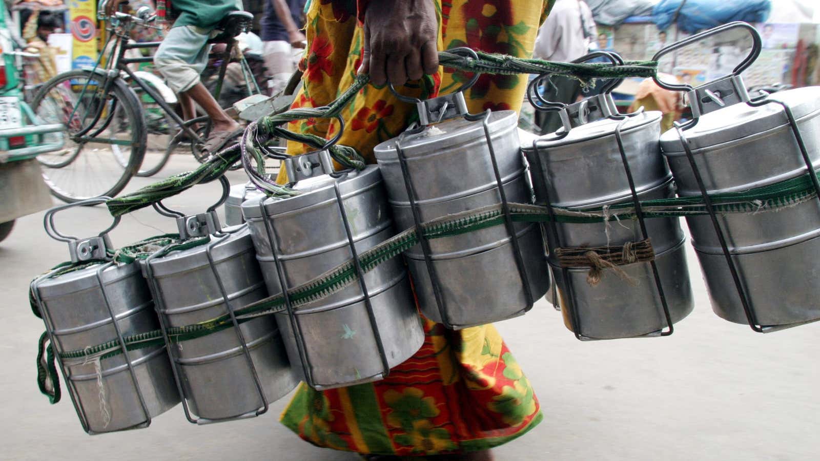 Tiffin lunch carriers, like the ones being carried through a street in Dhaka, are a perfect example of convenient, reusable design that predates disposable plastic by a longshot.
