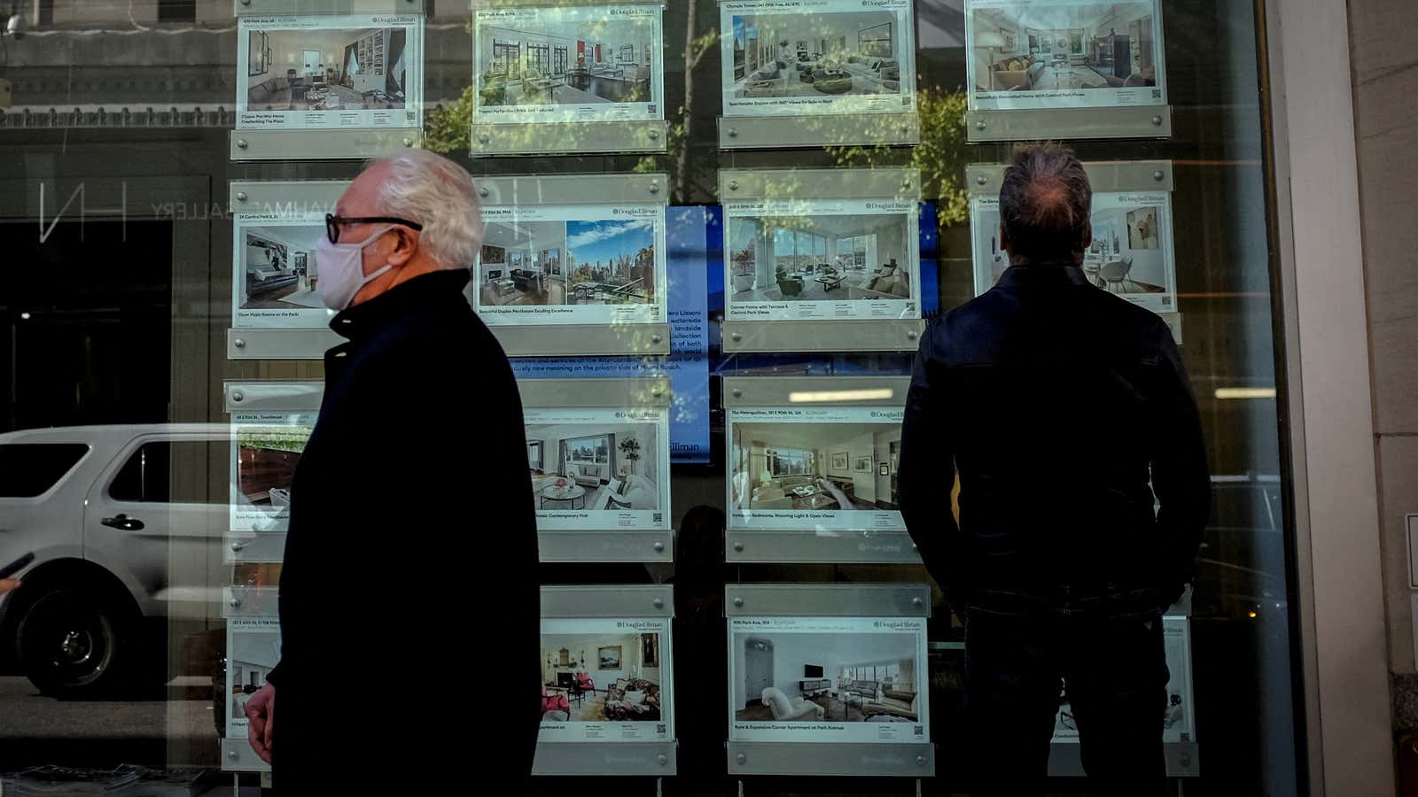 A man looks at advertisements for luxury apartments and homes in the window of a Douglas Elliman Real Estate sales business in Manhattanâ€™s upper east side neighborhood in New York City, New York, U.S. October 19, 2021.