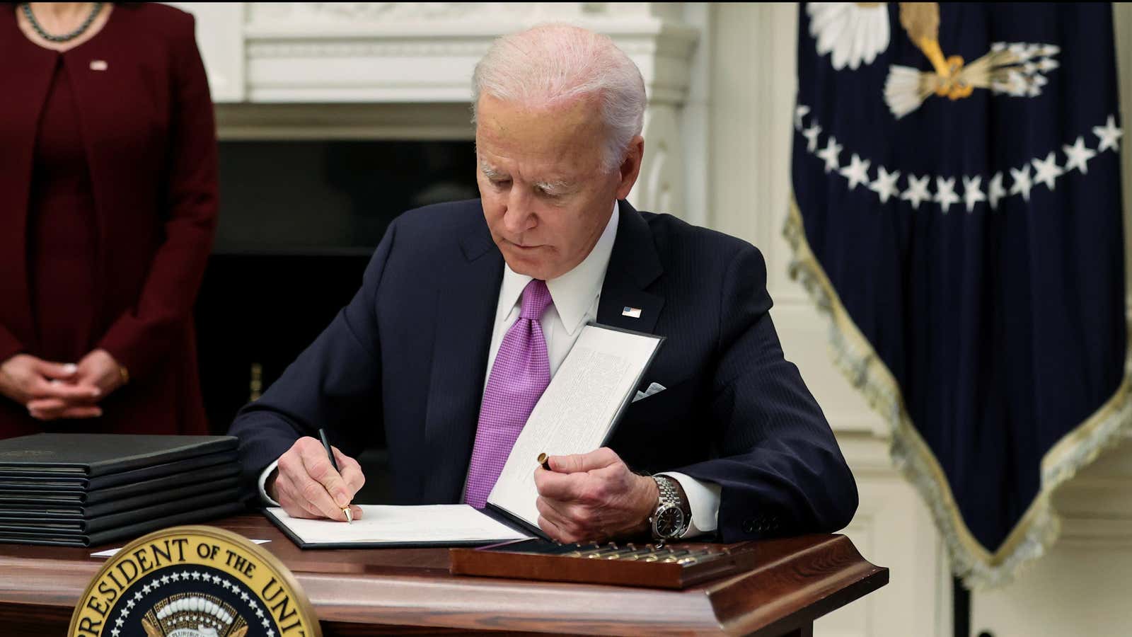 U.S. President Joe Biden signs an executive order as part of his administration’s plans to fight the coronavirus disease (COVID-19) pandemic during a COVID-19 response…