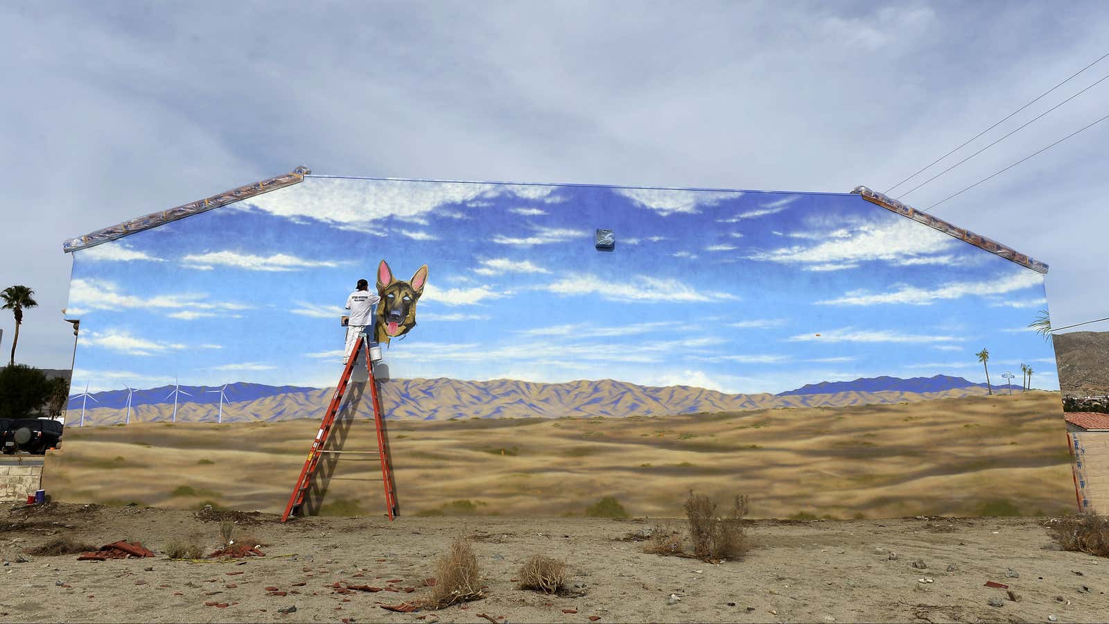 An artist paints a mural in California–where the author once took a spur of the moment of cross-country road trip.