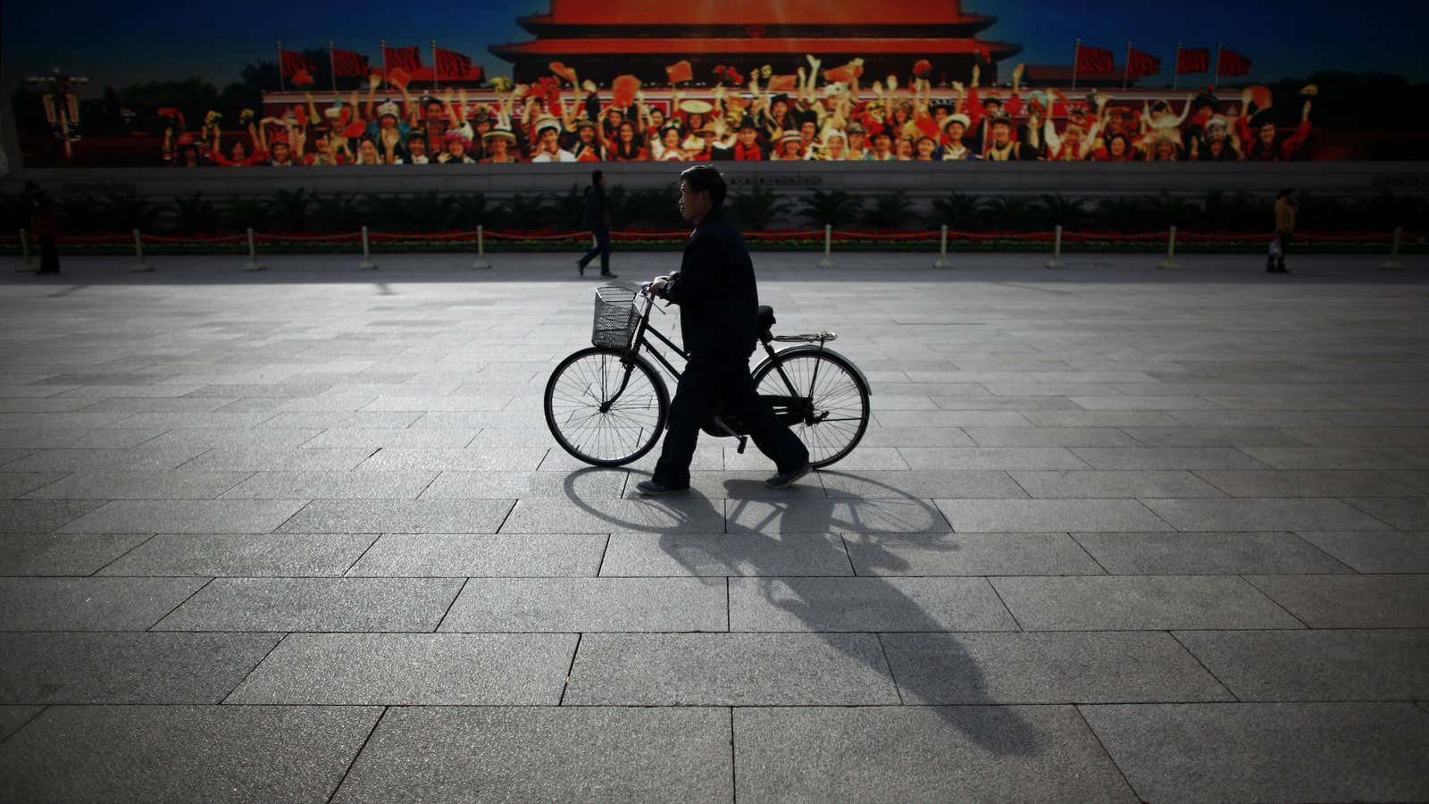 A man walks in front of a video promoting the Chinese Communist party in Beijing’s Tiananmen Square.