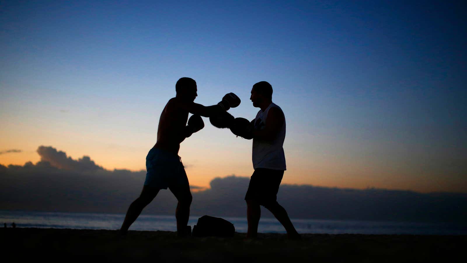A boxer and his trainer practice before sunrise on Sydney’s Bondi Beach.