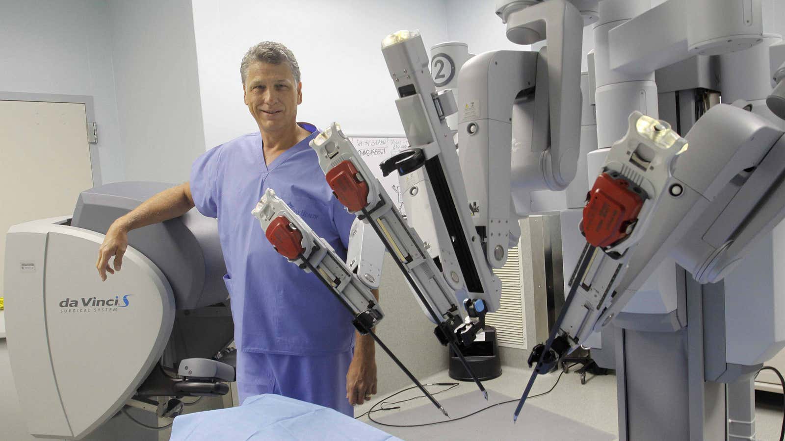 A doctor stands next to the Da Vinci Surgical System robotic surgical machine in Springfield, Mo.