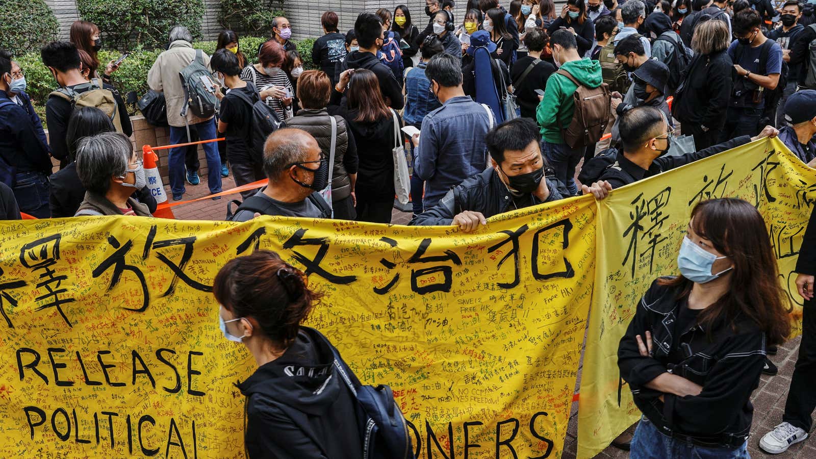 Supporters of pro-democracy activists hold banners as they queue up for a court hearing over the national security law outside West Kowloon Magistrates’ Courts, in…