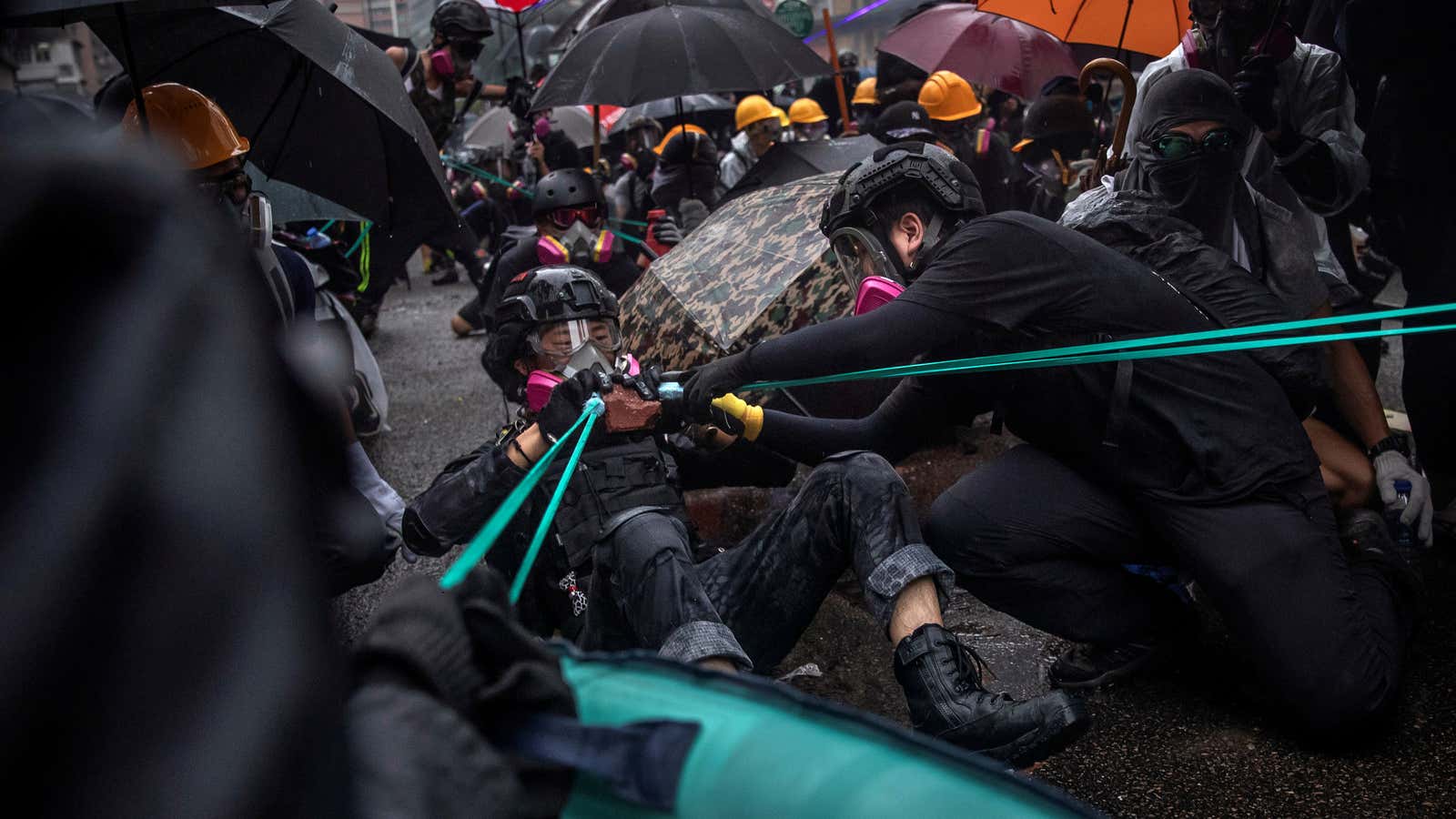 Anti-extradition bill protesters use slingshots to hurl bricks as they clash with riot police during a demonstration to demand democracy and political reforms, in the…