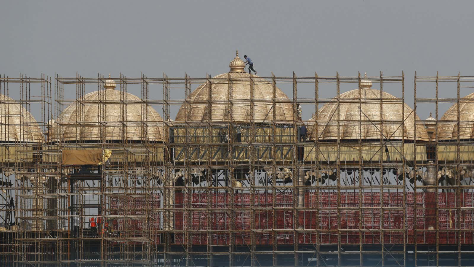 Workers erect scaffolding to build a stage at the venue of World Culture Festival on the banks of the river Yamuna in New Delhi, India,…