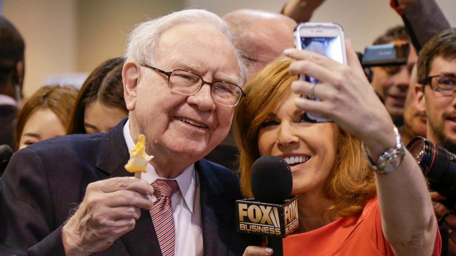 Buffett holds an ice cream bar as he poses for a selfie.