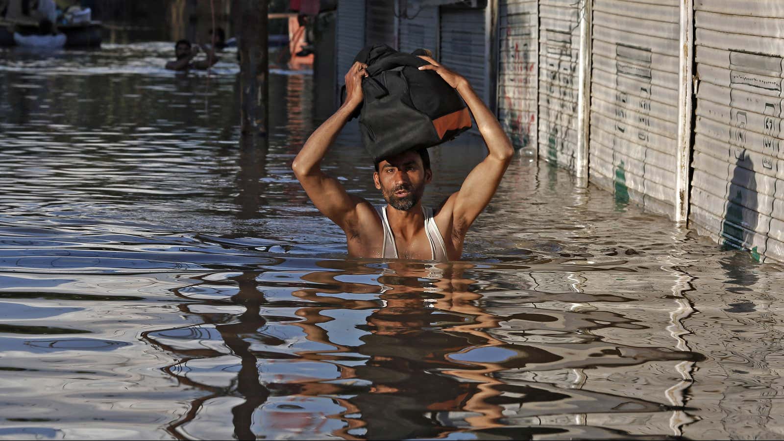 A Kashmiri man wades through a flooded street in September 2014.