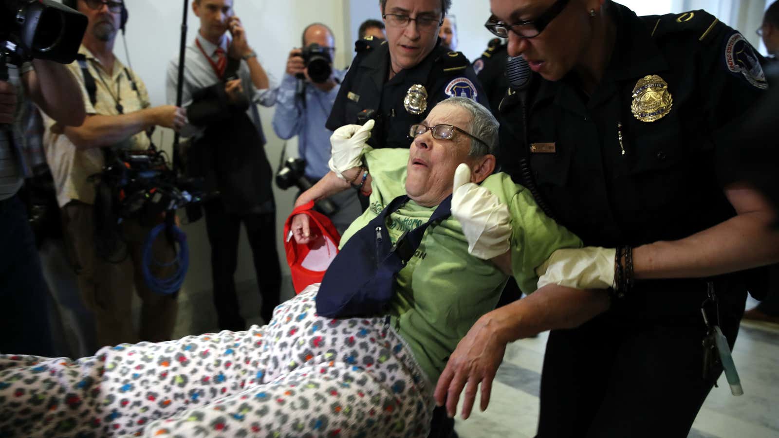 Demonstrators protesting cuts to Medicaid are removed from the hall outside Republican leader Mitch McConnell’s office.