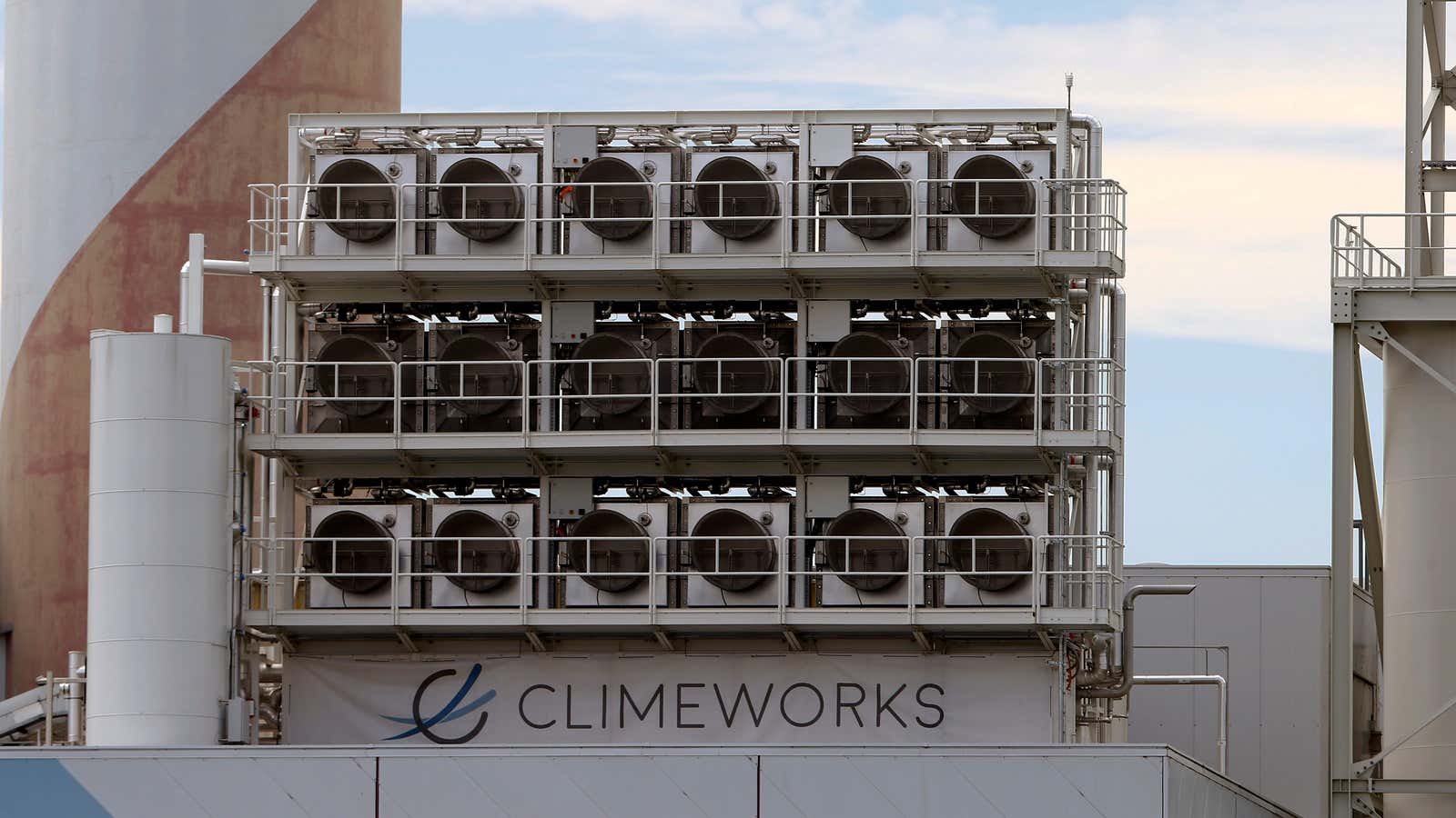 A row of carbon capture machines, which resemble air conditioning units, sits above a waste incineration plants.