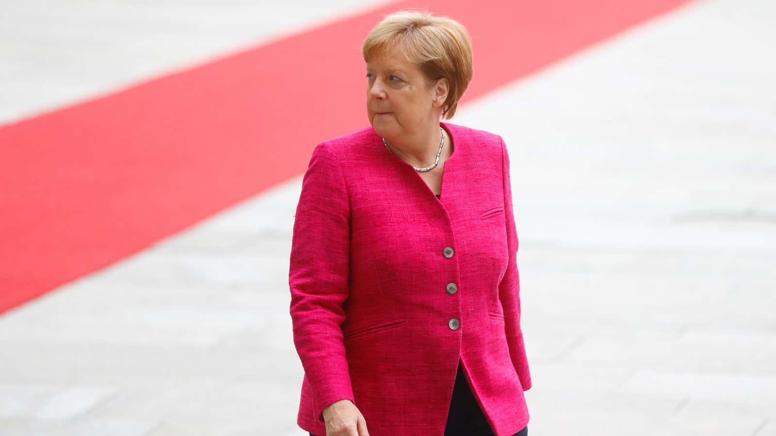 German chancellor Angela Merkel looks on.