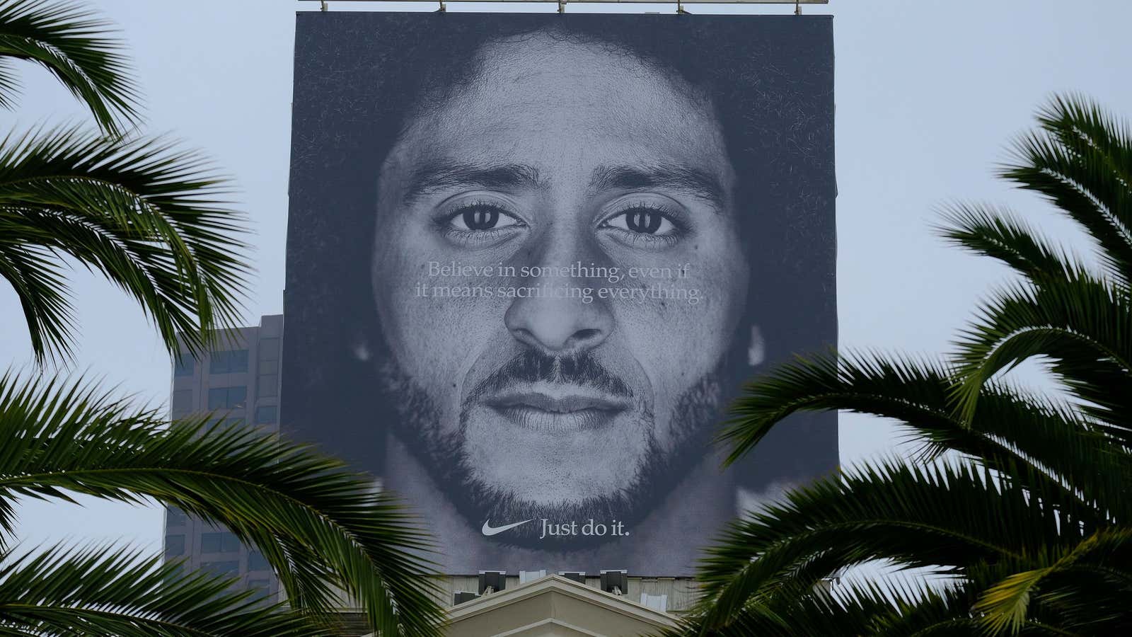 Palm trees frame a large billboard on top of a Nike store that shows former San Francisco 49ers quarterback Colin Kaepernick at Union Square, Wednesday,…