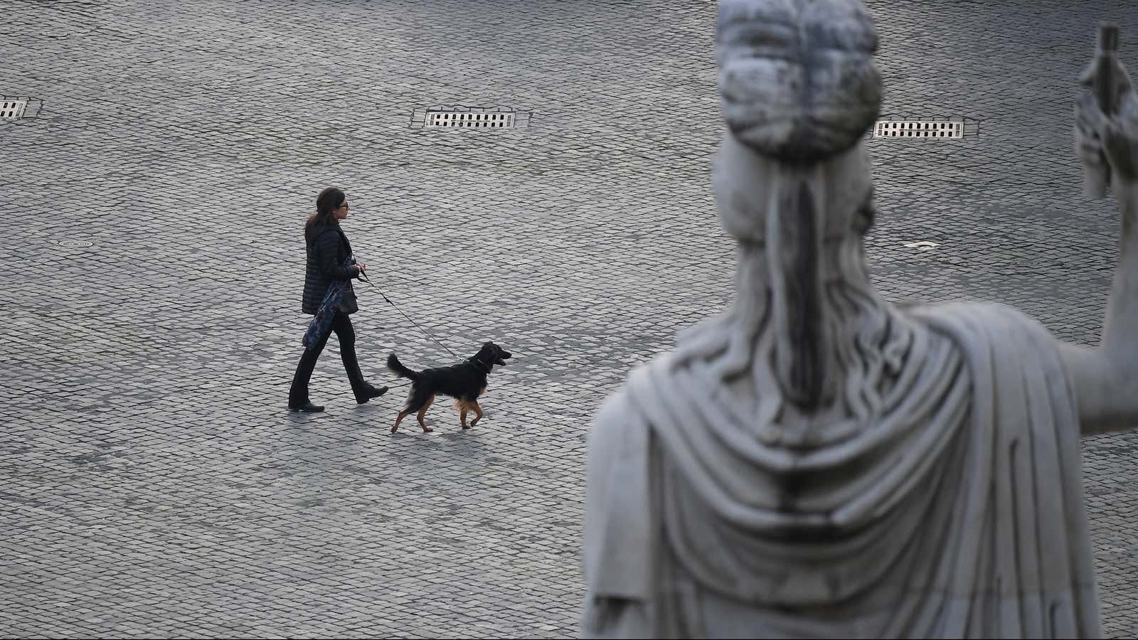 A woman walks her dog in Rome.