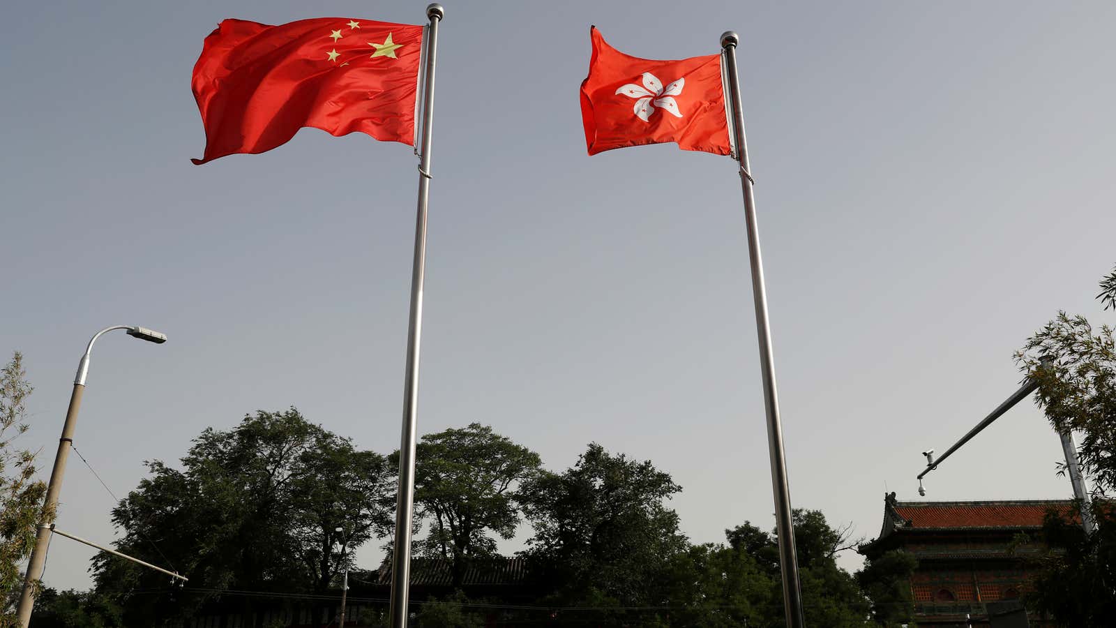 The Chinese and Hong Kong flags flutter at the office of the Government of the Hong Kong Special Administrative Region, ahead of a news conference…