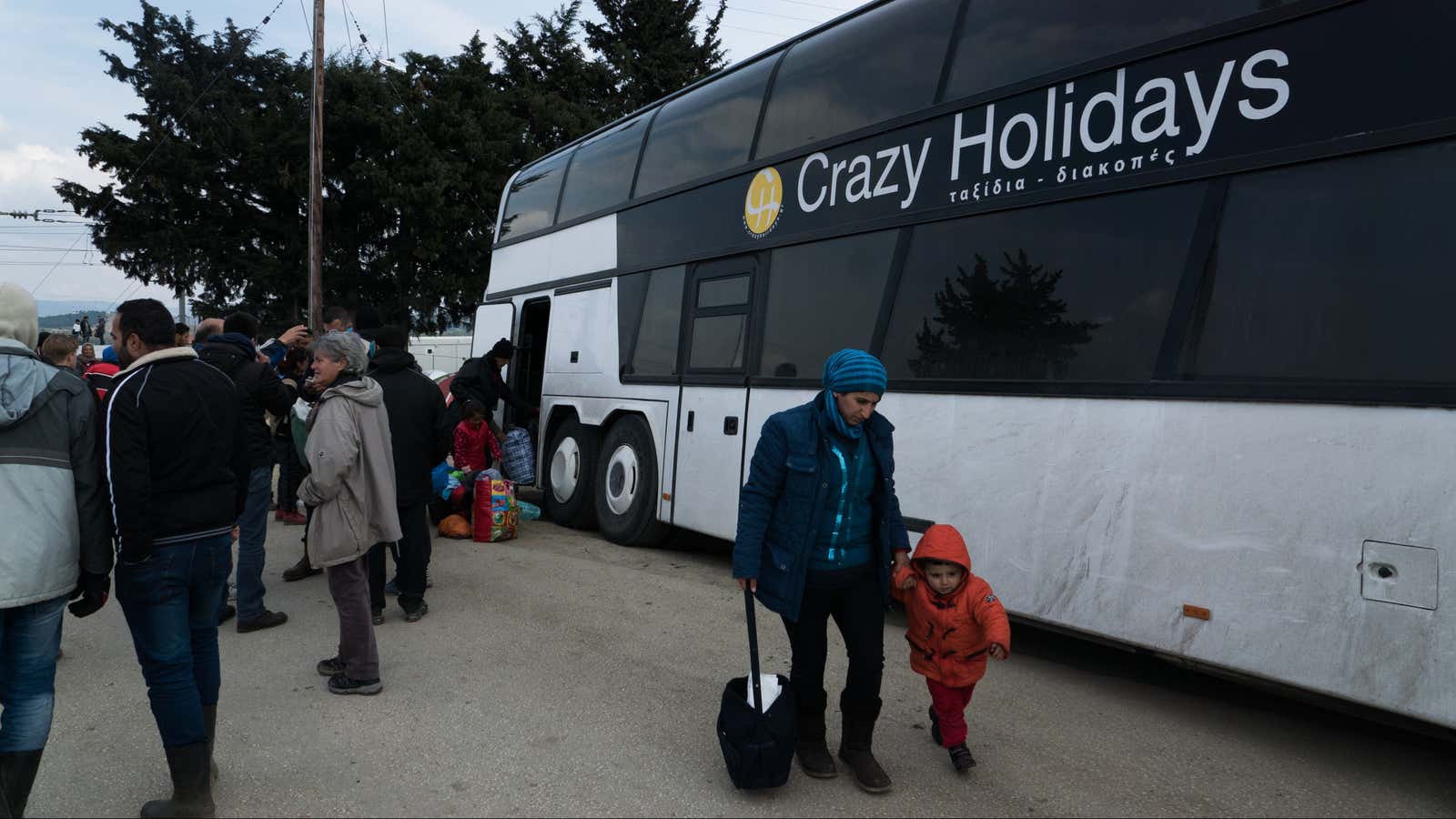 Refugees load their baggage into a bus bound for Athens.