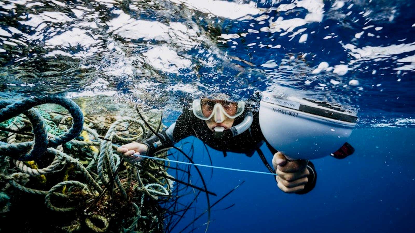 A diver attaches a GPS tracker onto ghost fishing nets.
