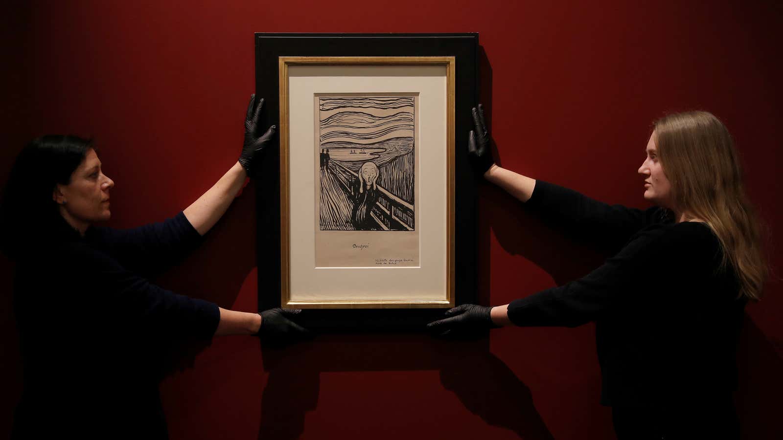 British Museum workers hang the black and white lithograph.