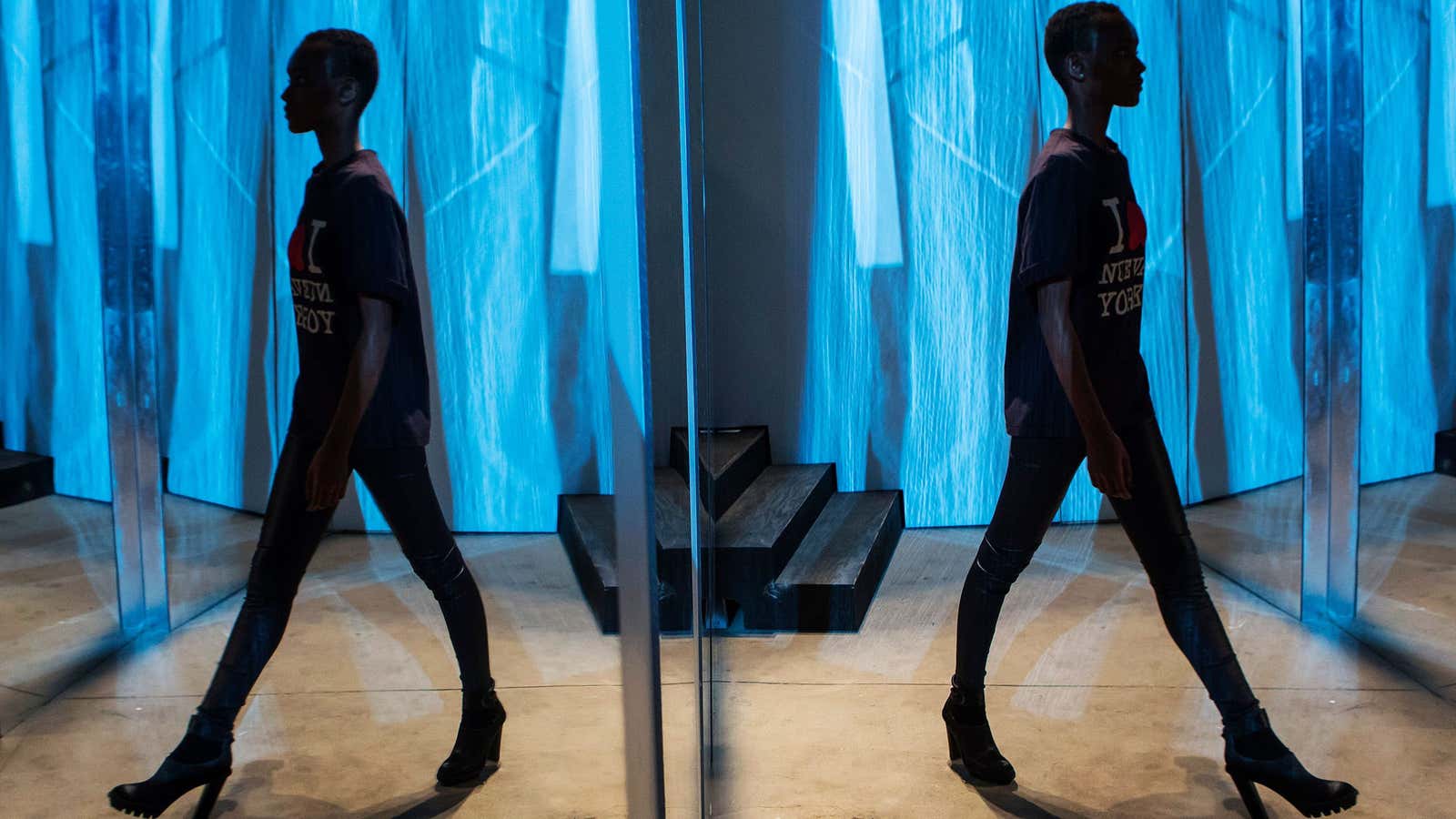 A model is seen reflected in a mirror during a fashion show rehearsal