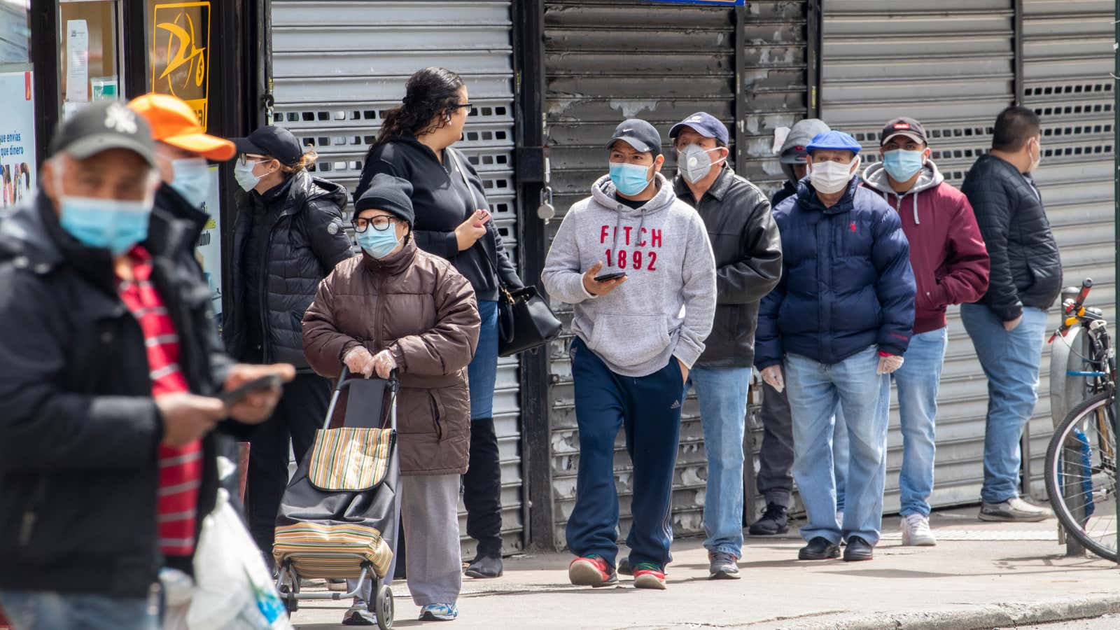A line of people wearing face masks in New York City.
