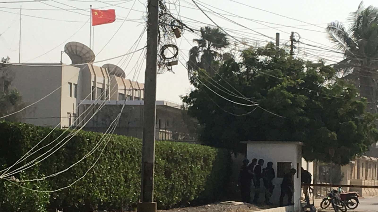 Paramilitary forces and police take cover behind a wall during an attack on the Chinese consulate in Karachi.