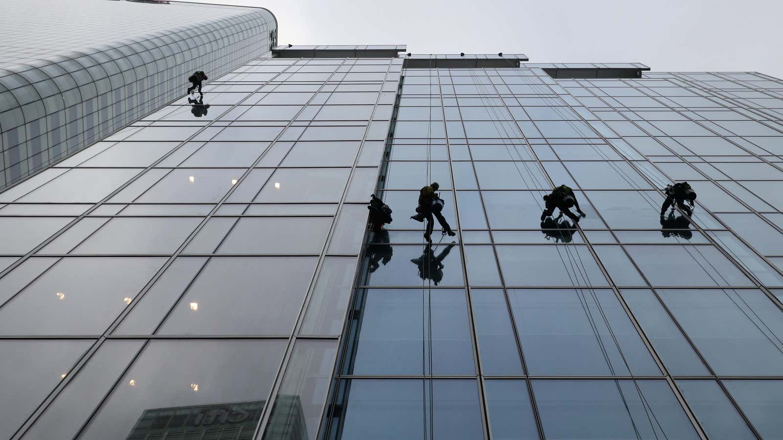Workers clean the windows of KPMG, which has the worst failure rate of the Big Four: 50% in 2017