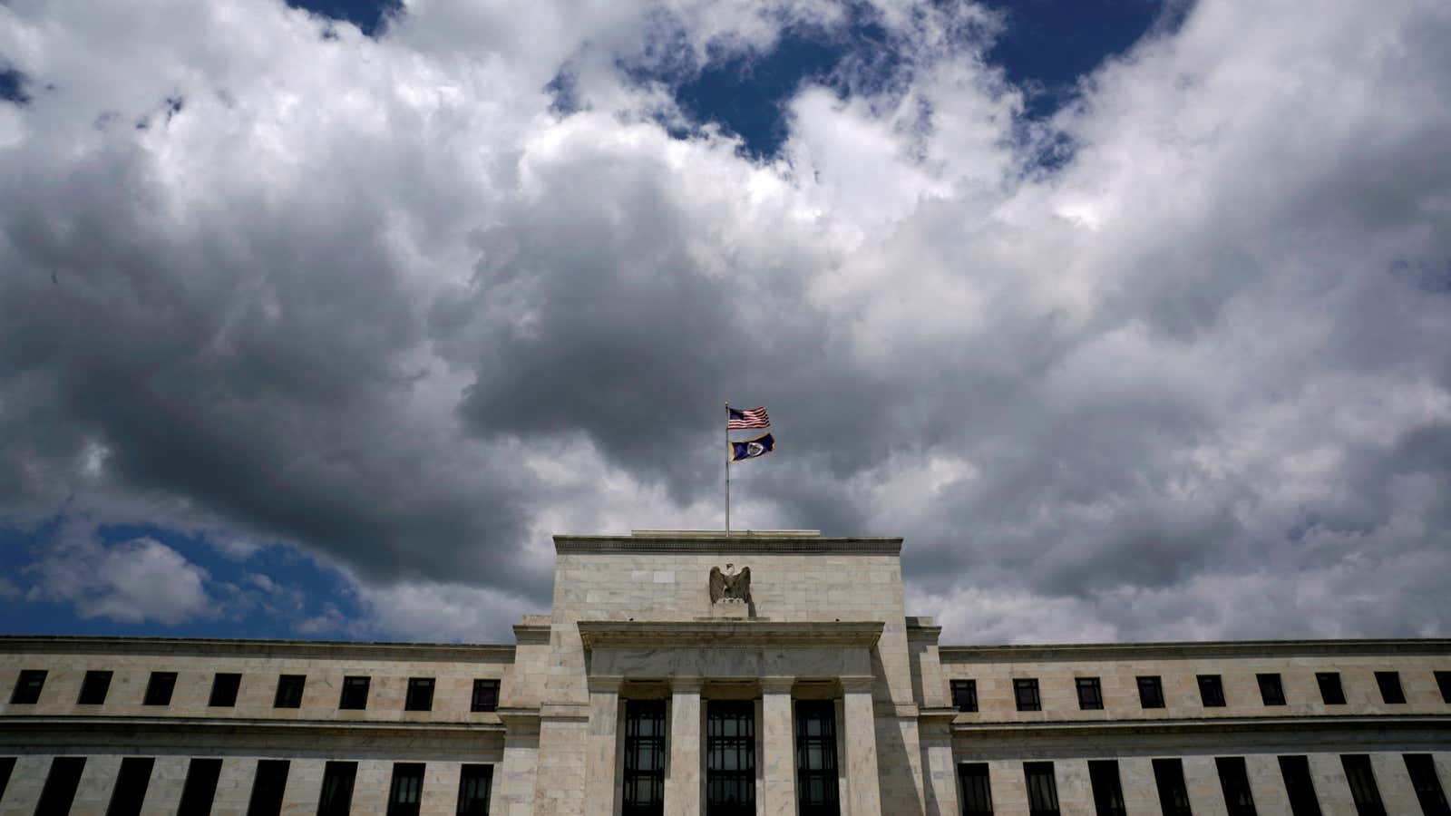 FILE PHOTO: Flags fly over the Federal Reserve Headquarters on a windy day in Washington, U.S., May 26, 2017. REUTERS/Kevin Lamarque/File Photo/File Photo/File Photo –…