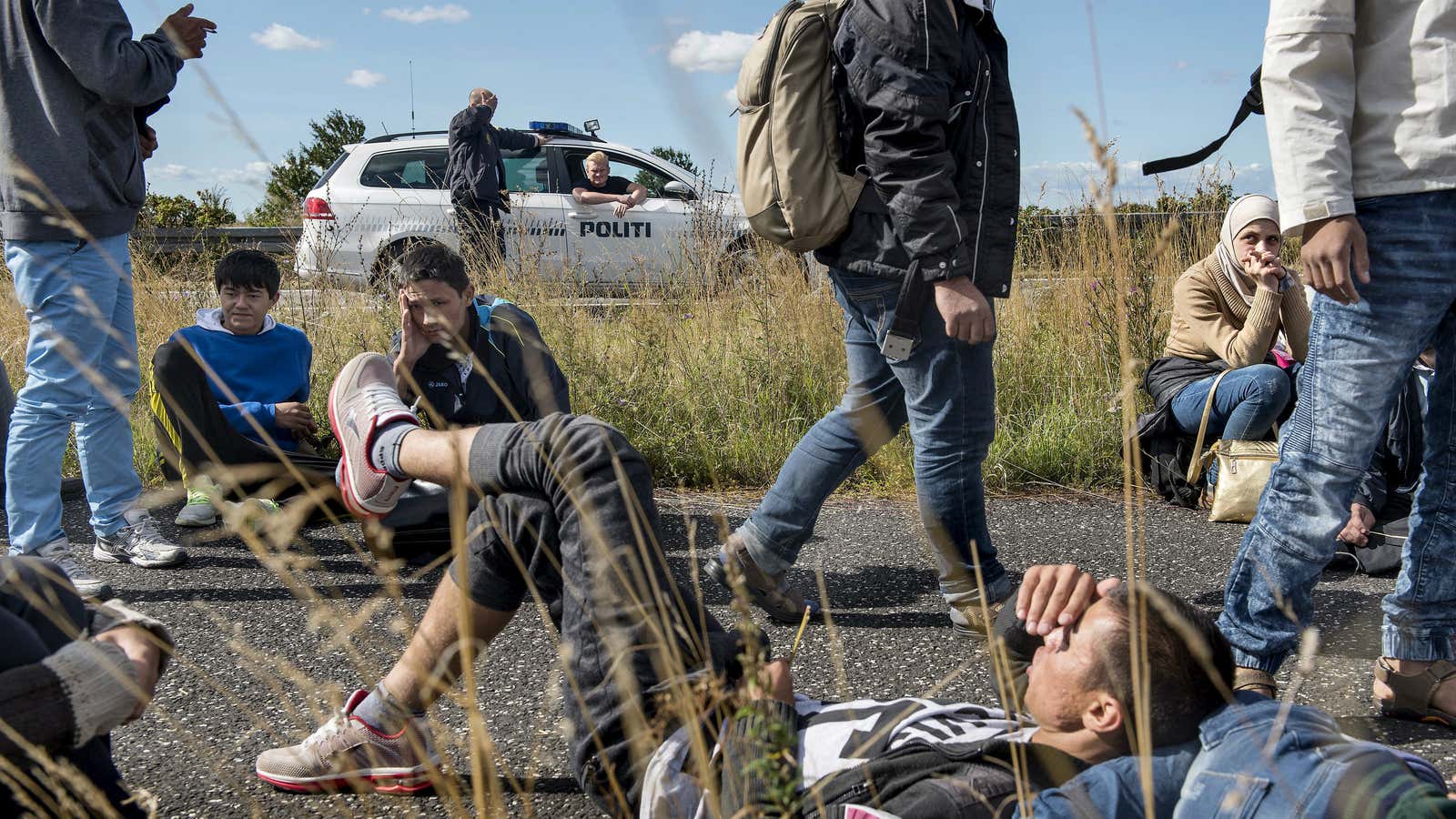 Syrian refugees walk on a highway in Denmark.