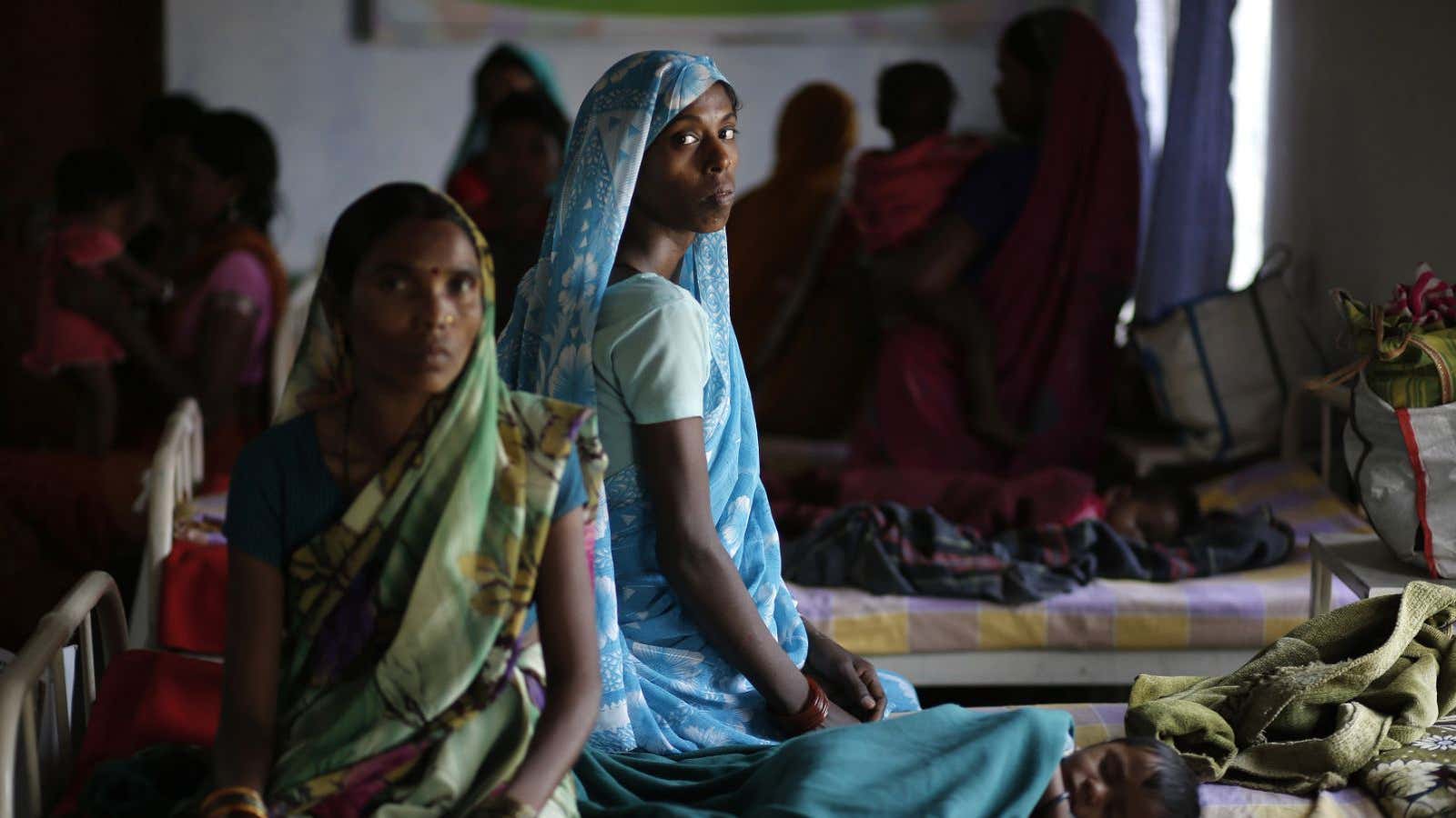 Kekti Bai (C), who underwent a sterilisation surgery at a government mass sterilisation camp, watches while other women sit inside a hospital at Bilaspur district…