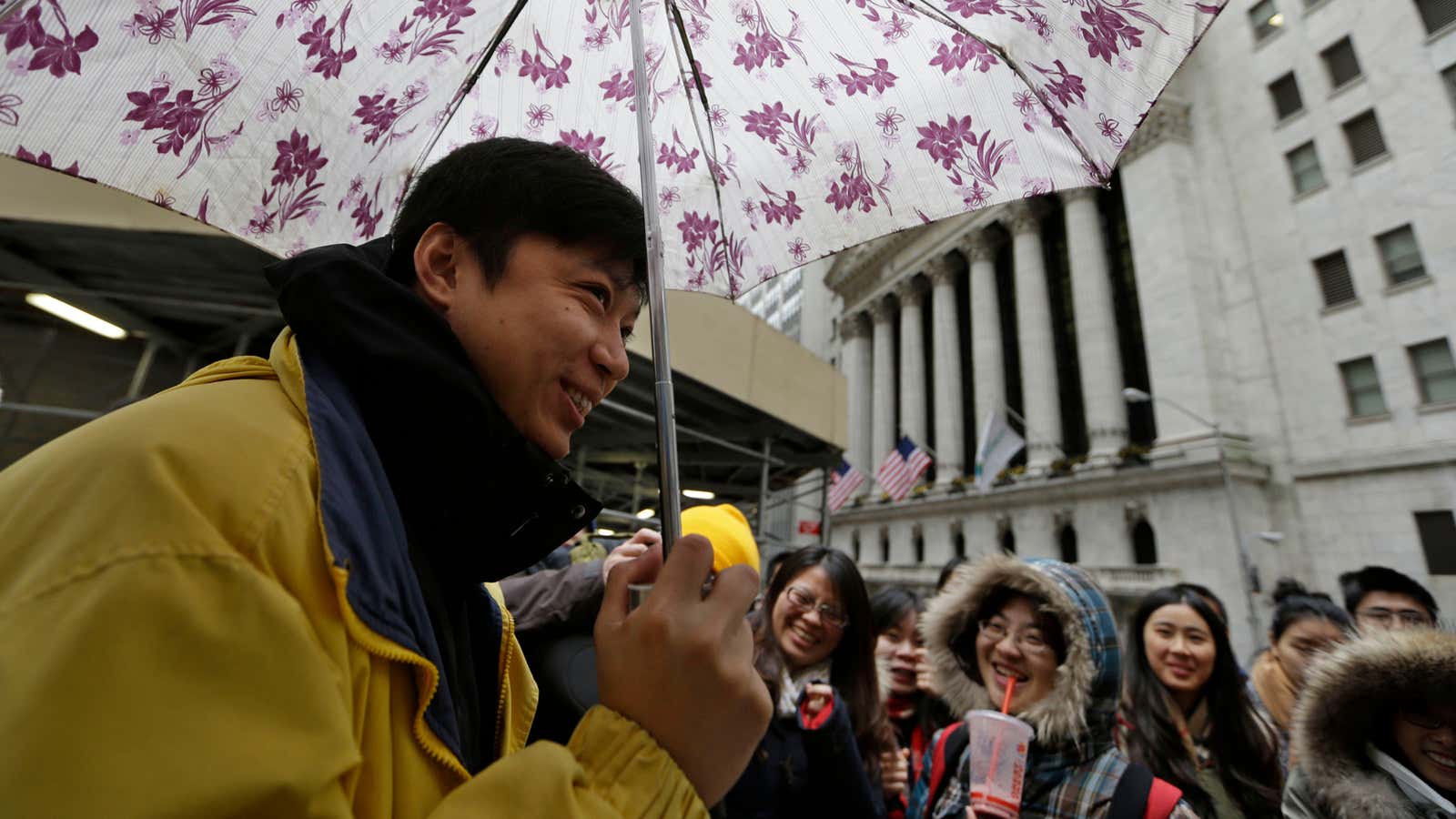 A tour guide in New York City shows Chinese tourists Wall Street, a monument to American avarice.