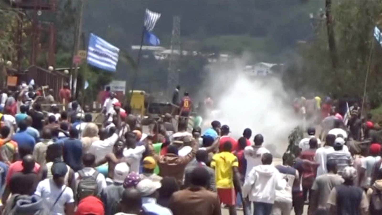 Protesters waving separatist Ambazonian flags amid police tear gas in the English-speaking city of Bamenda, Cameroon.