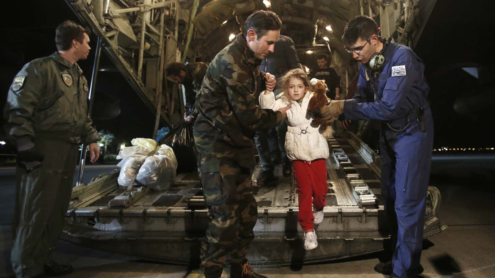A man (C) and his daughter (2nd L), both rescued from the Norman Atlantic ferry, disembark from a Greek Airforce C-130 military cargo aircraft at the Elefsina military airport near Athens December 29, 2014.