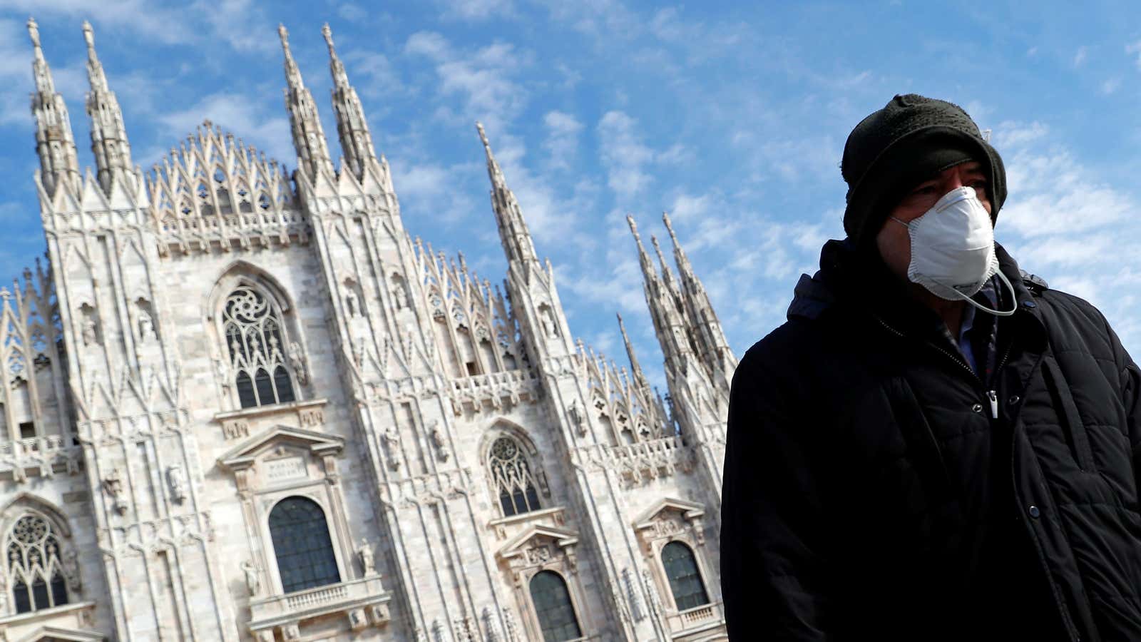 A man in front of the Duomo Cathedral in Milan