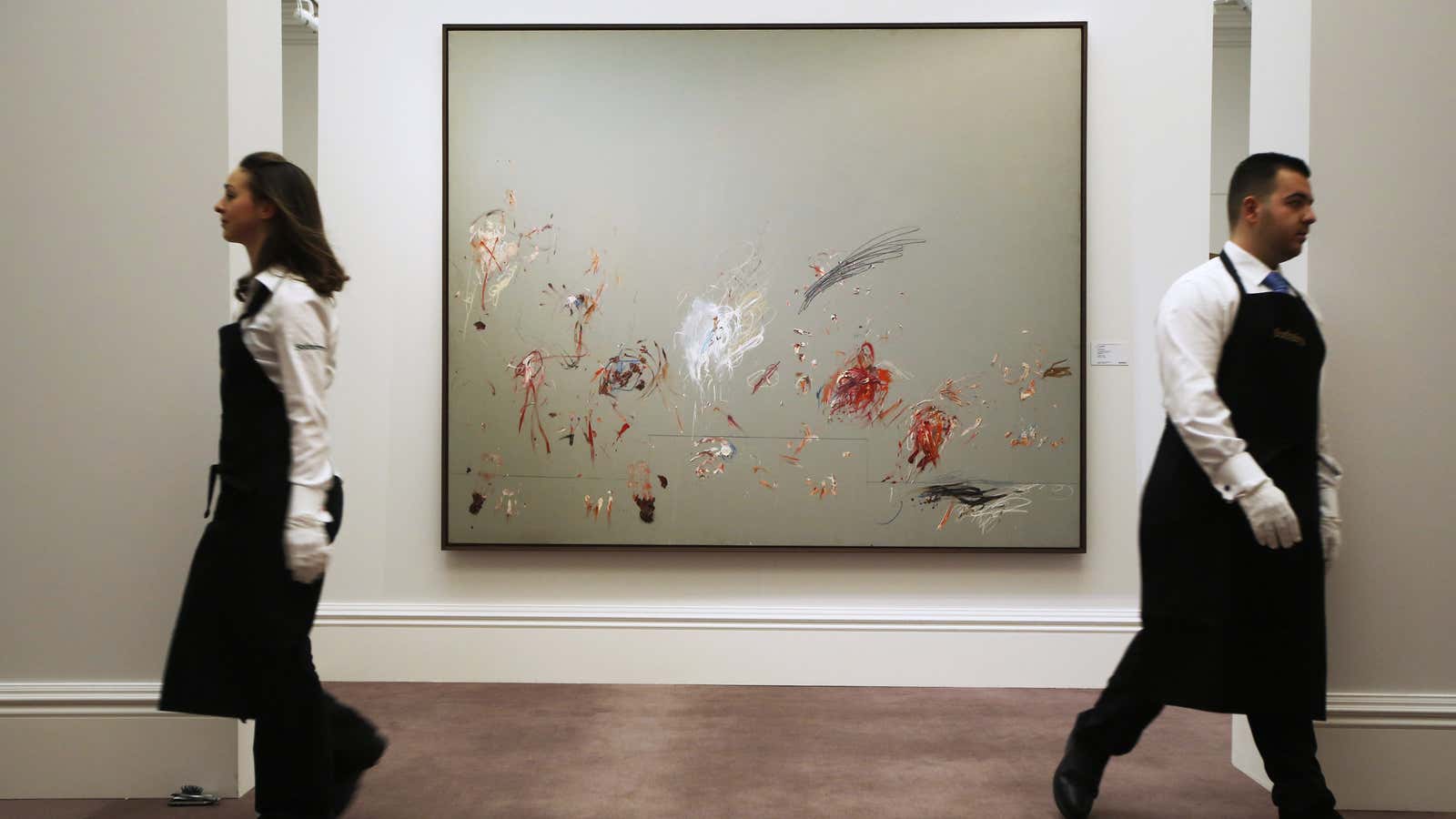 Employees pose for a photograph with artist Cy Twombly’s artwork “Untitled (Rome)” at Sotheby’s auction house in London.