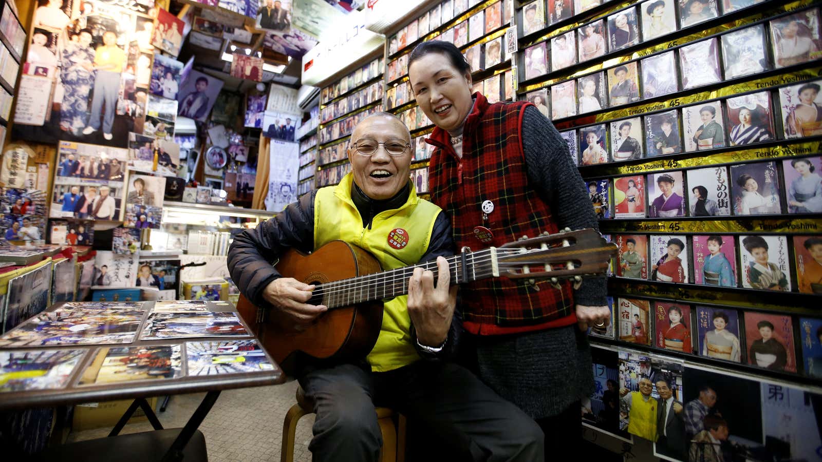 Kazuhiko Kobayashi, 80, and his wife Mieko Kobayashi, 73, pose for a photograph at their music shop named Ameyoko Rhythm, specialised for Enka, traditional Japanese popular ballad, in Tokyo’s Ameyoko shopping district, Japan, February 8, 2018. “I met her in 1963, 55 years ago. She was a classmate of my younger sister. One day she came over to my house and I took a shine to her because she was so charming. Since that day on, I called her every day. In the beginning, she did not seem to be interested in me, but I conveyed my passion to her. On our first date, I waited at a meeting place for an hour. It turned out she had been advised by her mother and older sister to be late for an hour to see whether I was serious about her. My feelings got through to her, and we married on October 15, 1964, five days after the opening ceremony of the Tokyo Olympics. Fifty four years have passed since then. We see each other most of the time, both at home and at this shop, which has been in business for about 50 years, but I still find her charming every day!” said Kazuhiko. REUTERS/Toru Hanai          SEARCH “GLOBAL LOVE” FOR THIS STORY. SEARCH “WIDER IMAGE” FOR ALL STORIES. – RC15DD1008E0