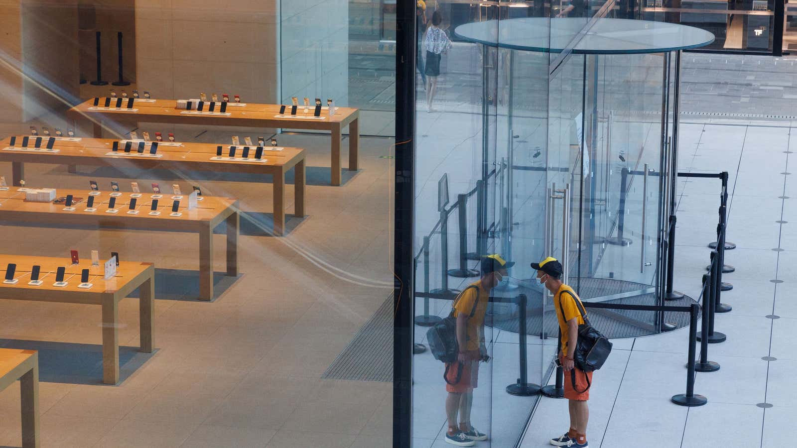 A man looks into a closed Apple store in a shopping district as the covid outbreak continues in Beijing.