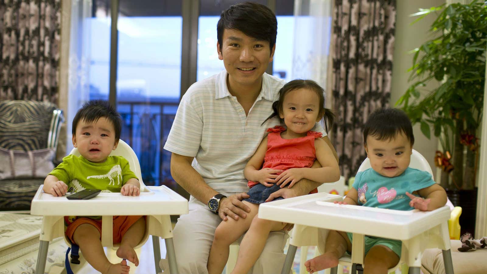 A businessman in Shanghai, Tony Jiang poses with his three children, born in California to an American surrogate.