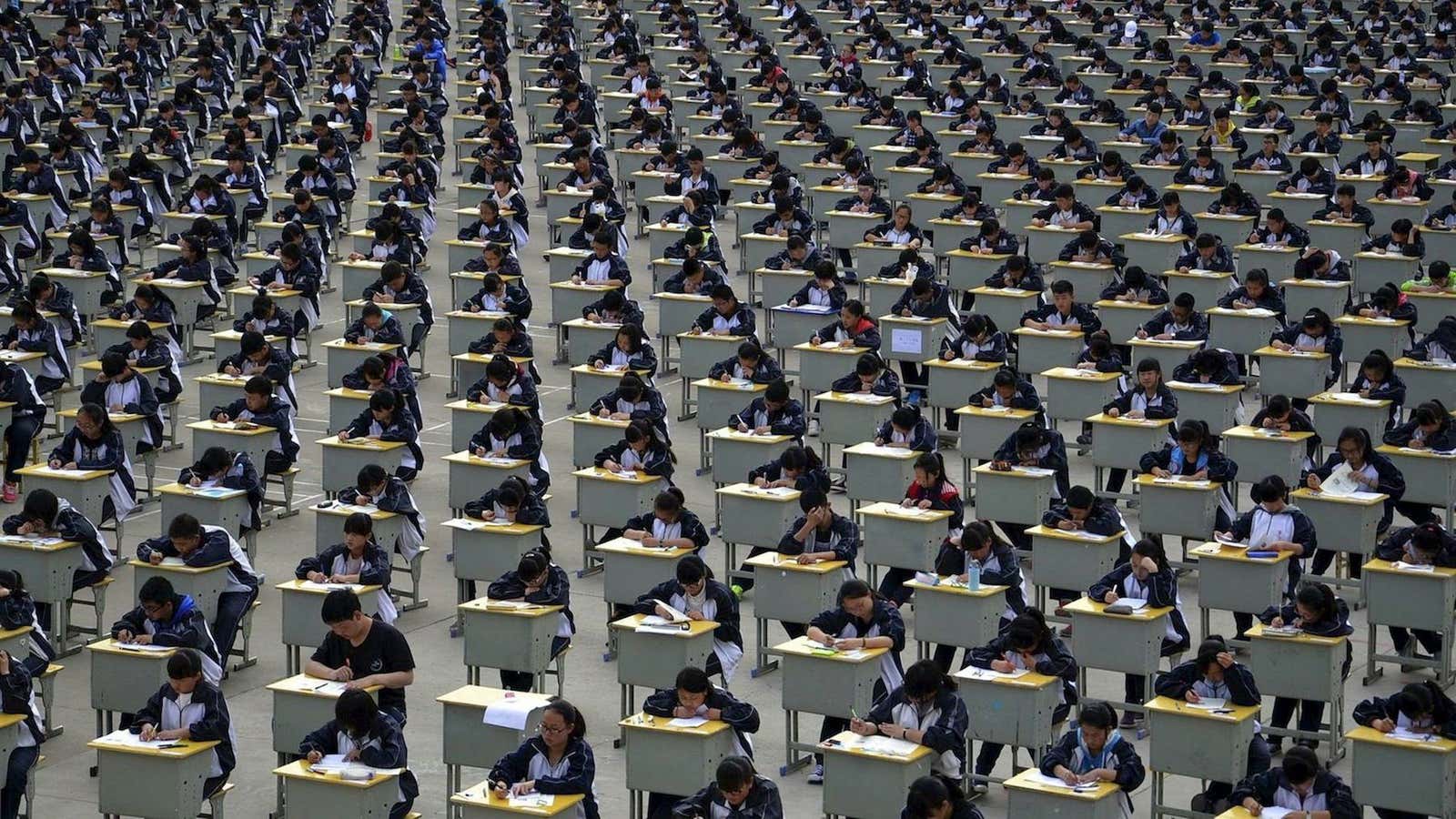 Freshmen university students take an exam in an open-air playground at a high school in Yichuan, Shaanxi province.