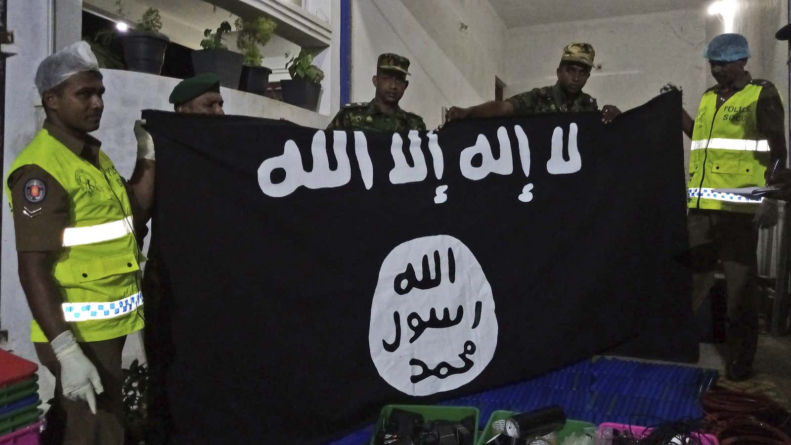 Sri Lankan police officers show an ISIS flag they recovered from militants in Sri Lanka.