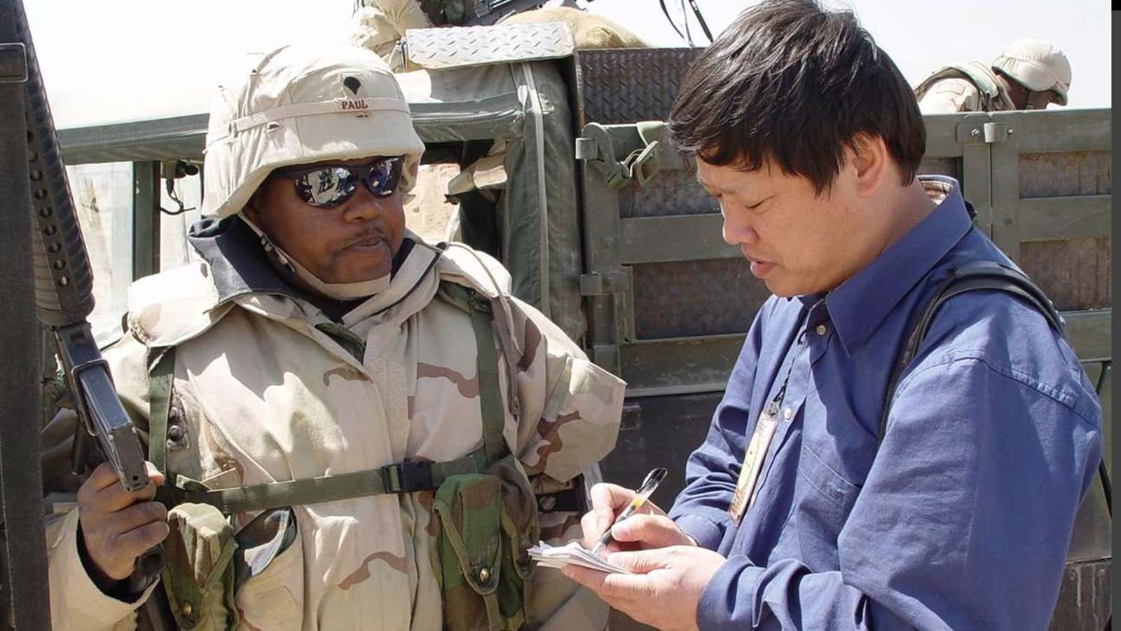 Hu Xijin interviews a US soldier at the Iraq-Kuwait border in 2003.