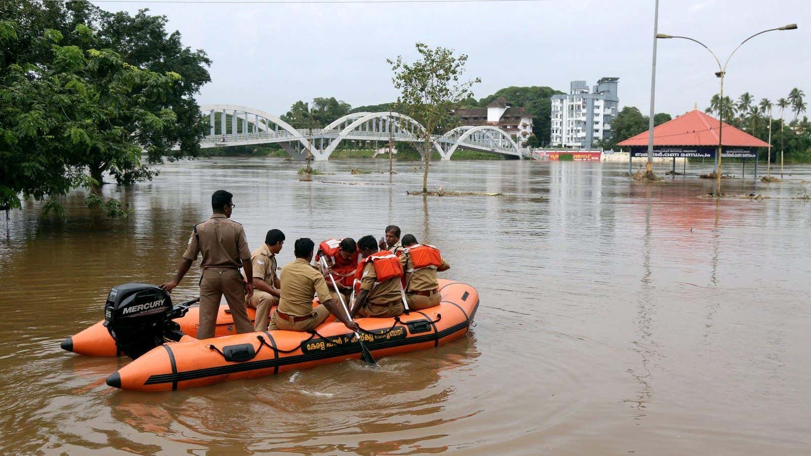 Rescue personnel patrol the flooded waters on the banks of Periyar River after the opening of Idamalayar and Cheruthoni dam shutters following heavy rains, on the outskirts of Kochi, August 10,2018.