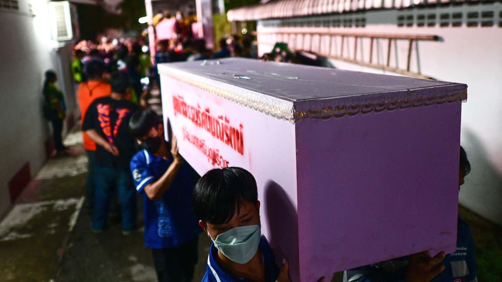 Rescue personnel carry a victims coffin at the hospital morgue in Udon Thani on October 6, 2022 following a mass shooting at a nursery by a former policemen.