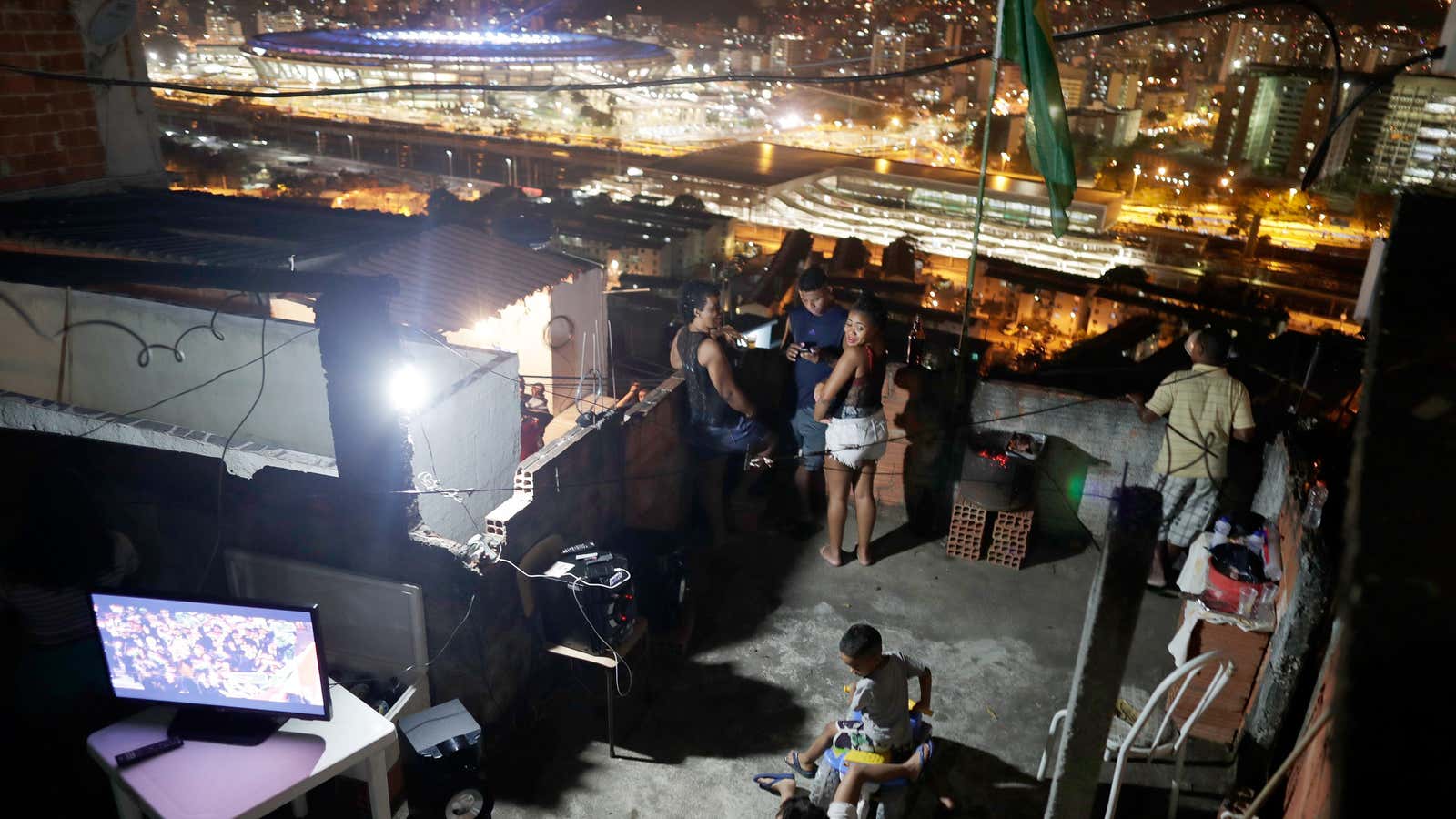 A family watches the opening ceremony from the Mangueira favela.