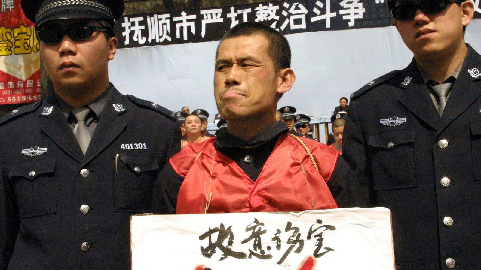Qi Jun, a convicted rapist is walked to his execution in 2002.