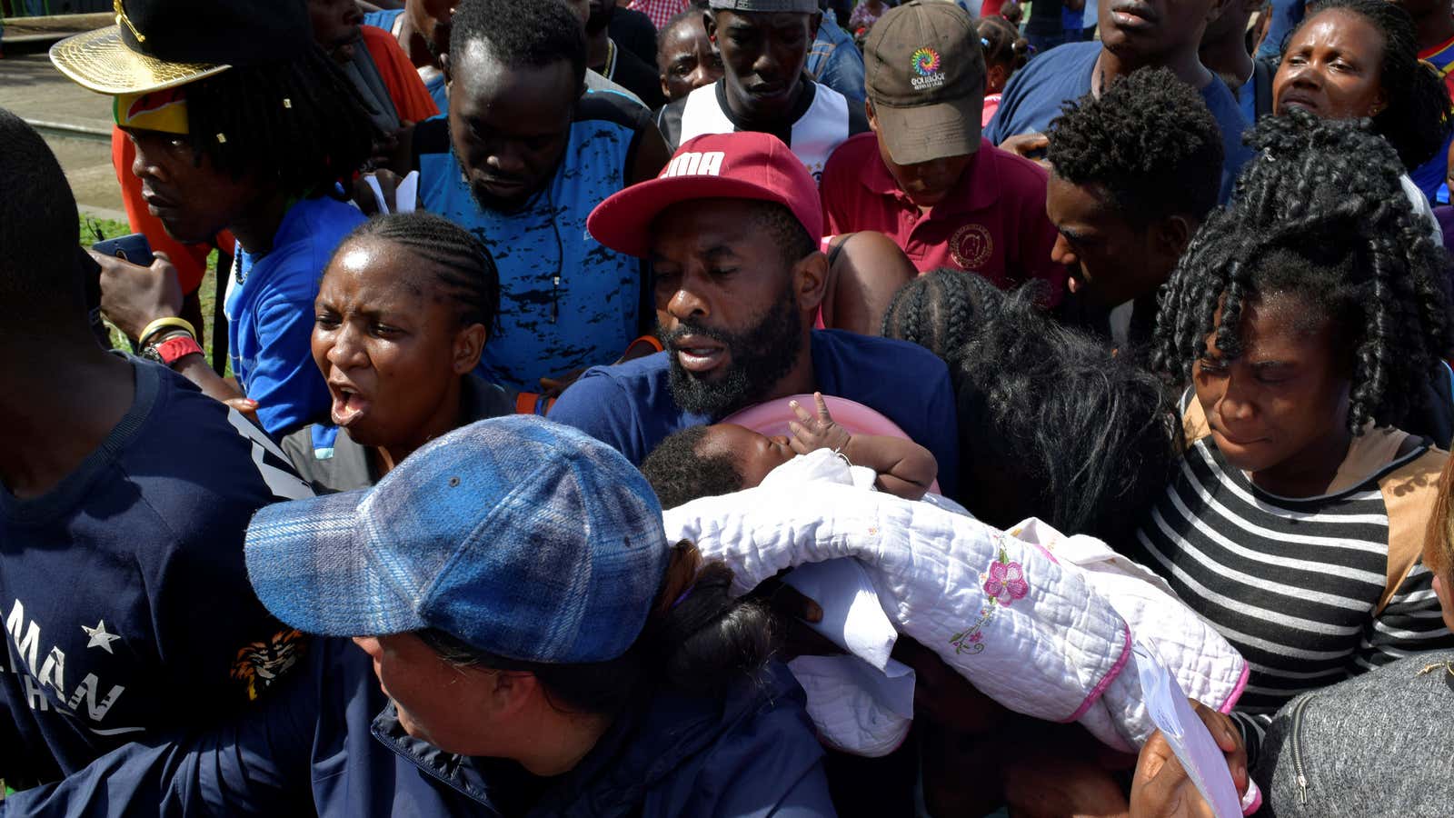 A migrant from Cameroon holds his baby while trying to enter the Siglo XXI immigrant detention center to request humanitarian visas, issued by the Mexican government, to cross the country towards the United States, in Tapachula, Mexico June 27, 2019.