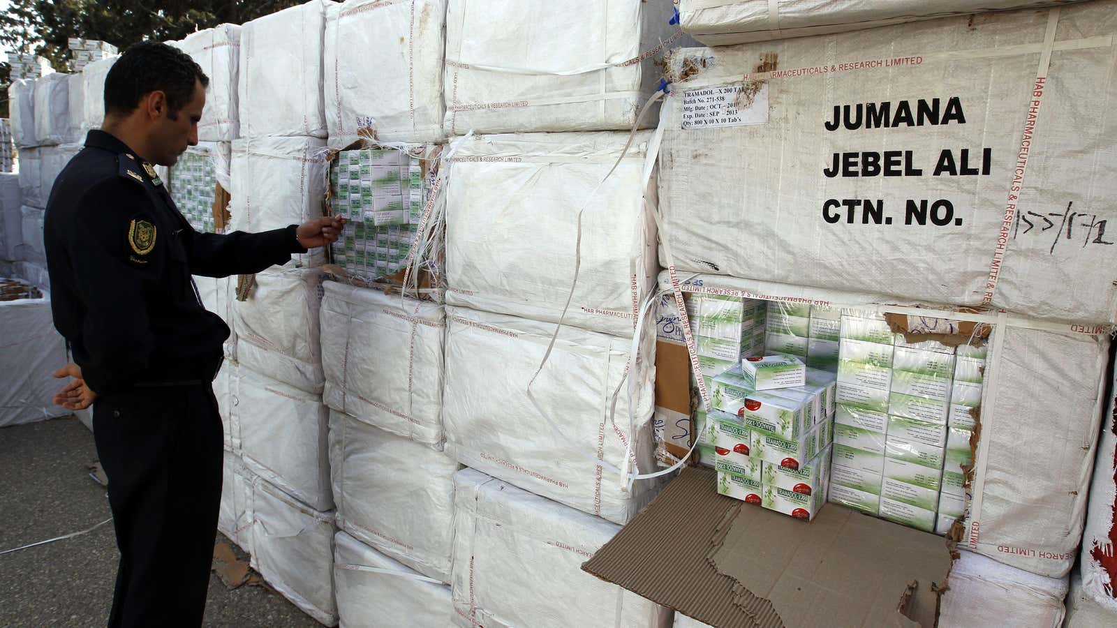 A Libyan police officer views a haul of prescription drug Tramadol seized from a shipping container in Tripoli