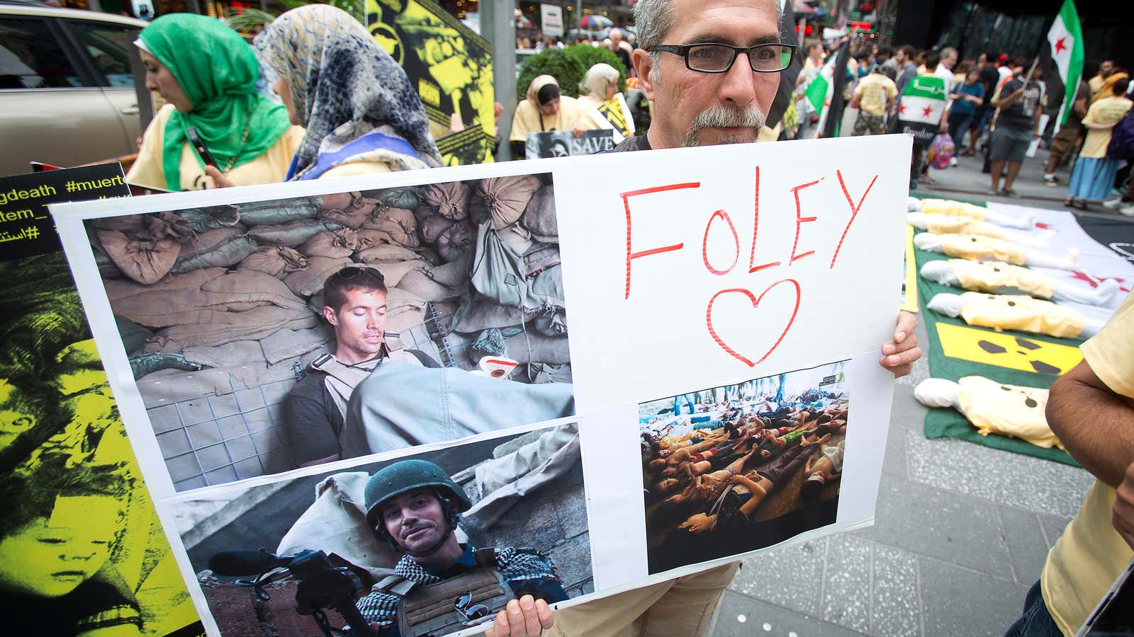 A man holds up a sign in memory of U.S. journalist James Foley during a protest against the Assad regime.