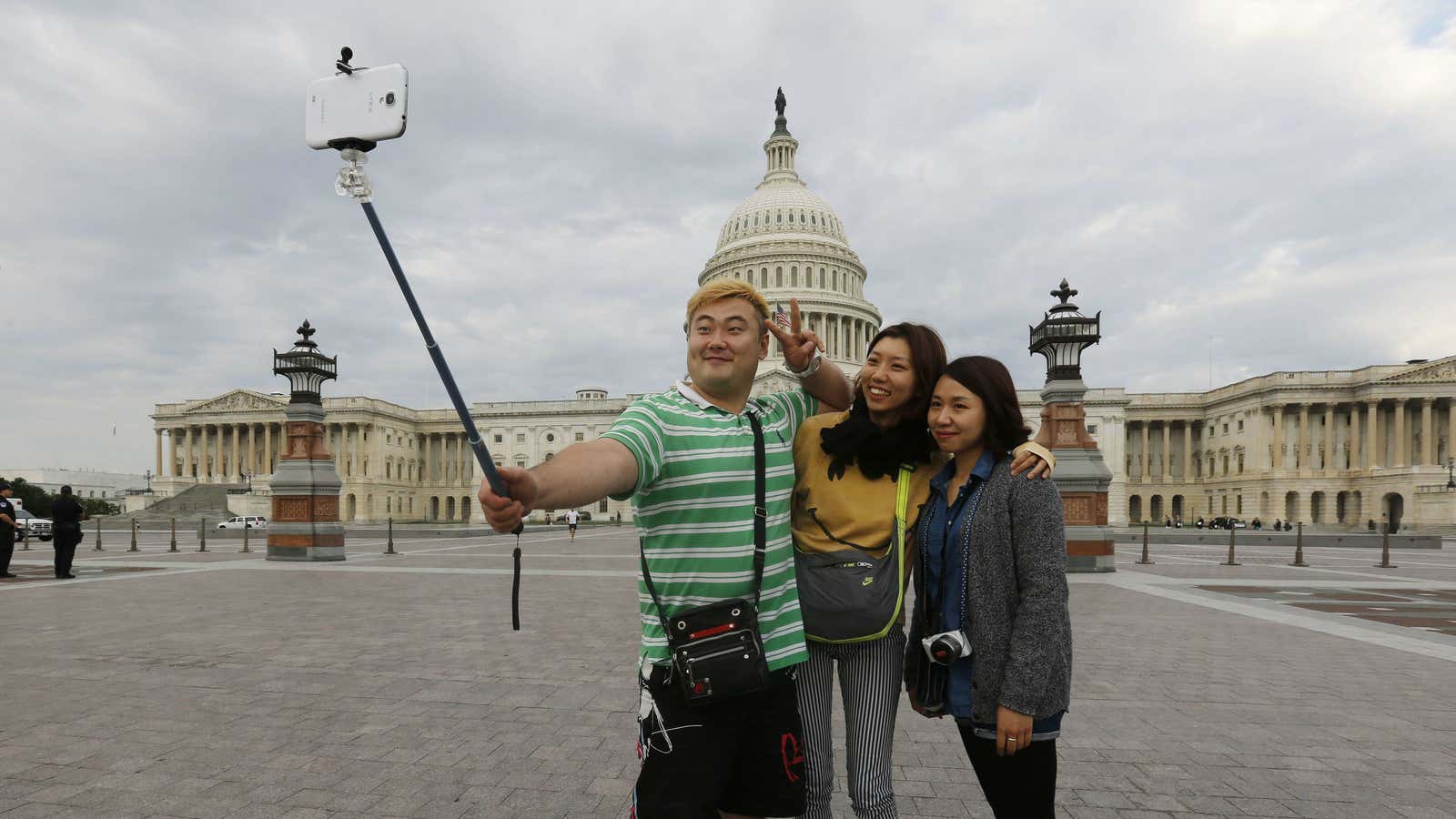 South Korean tourists (L-R) Heemok Ann, Eunyi Ji, and Mijung Jung take their own picture in front of the U.S. Capitol dome on Capitol Hill in Washington.
