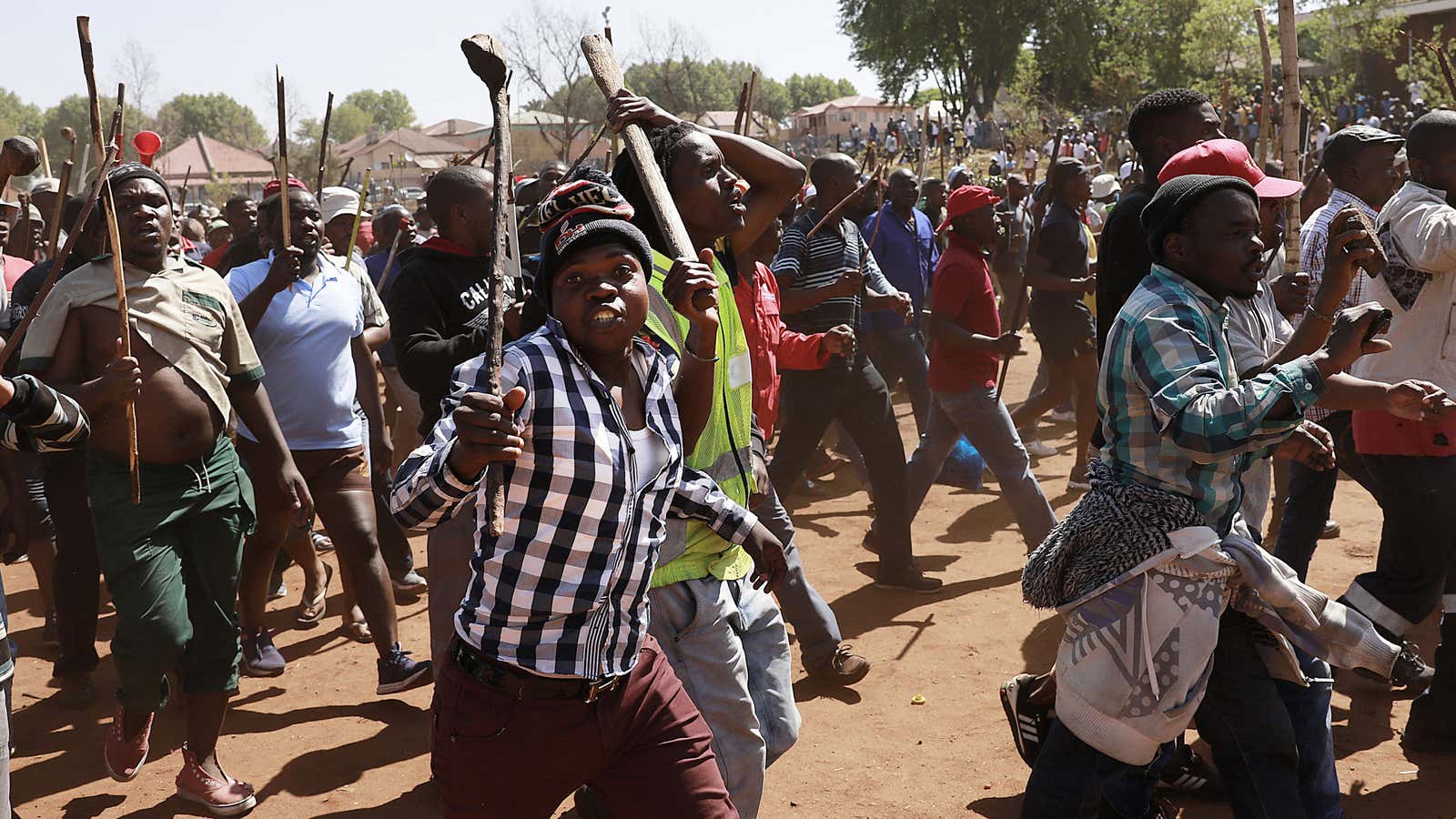 Residents of local hostels march with homemade weapons in Johannesburg. South African police say that two more people have been killed in Johannesburg, bringing to 12 the number of deaths