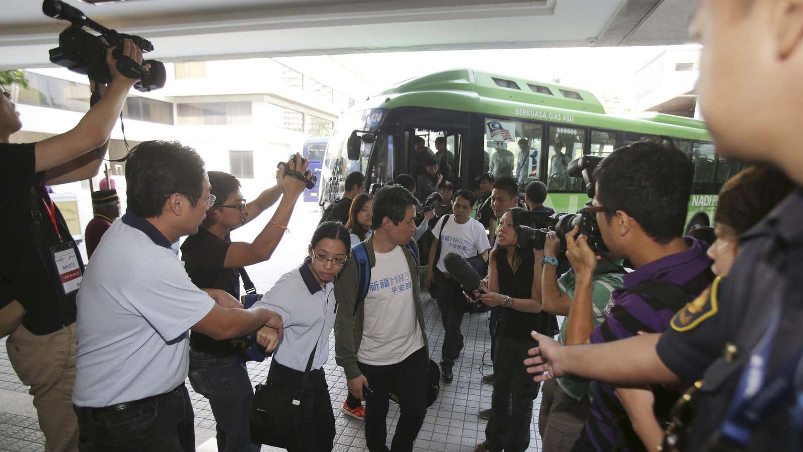 Reporters try to interview a new batch of Chinese relatives of passengers as they arrive at a hotel in Malaysia.