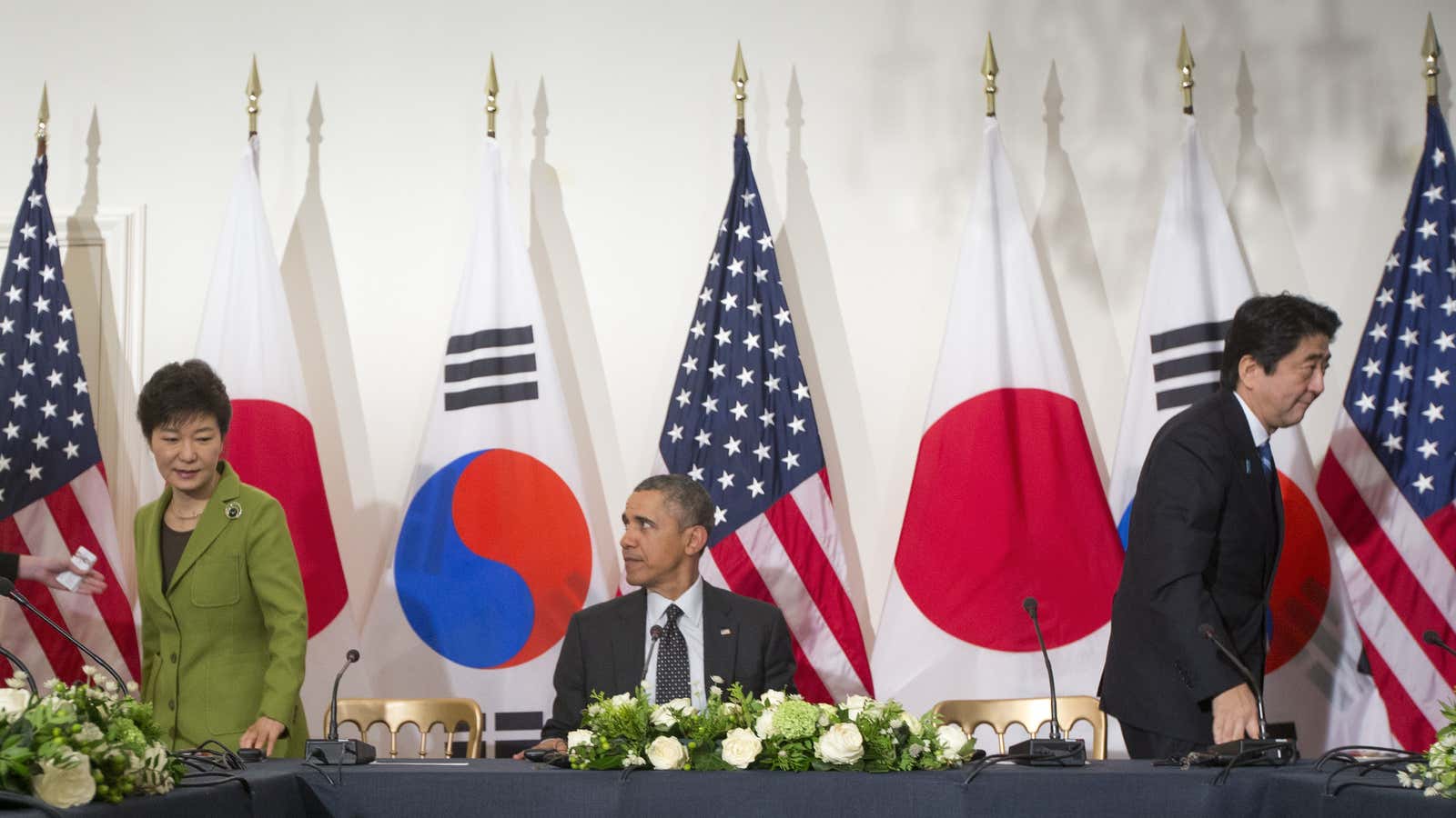 US president Barack Obama, center, watches South Korean president Park Geun-hye, left, and Japanese prime minister Shinzo Abe, right, move to their seats at the opposite ends of the table to start their trilateral meeting in March 2014.